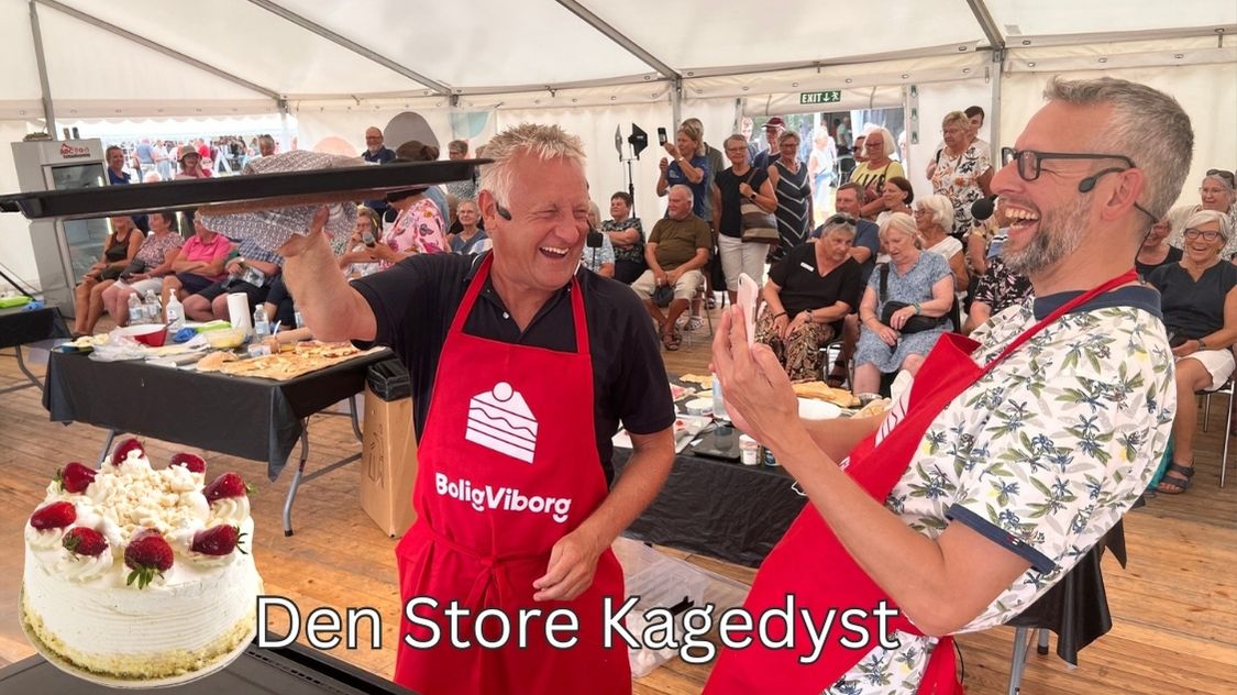 Billedet viser et livligt og festligt øjeblik fra Teambuilding: Den Store Kagedyst, hvor deltagerne er iført forklæder og dyster i at bage lækre kager foran et engageret publikum. Stemningen er fyldt med grin, fællesskab og konkurrenceånd – perfekt til firmaevents, der ønsker at kombinere samarbejde, kreativitet og hygge i én og samme aktivitet.